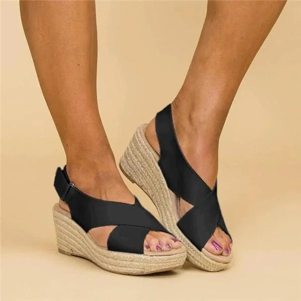 Women's black Aeris wedge platform sandals with crossover straps and espadrille sole.