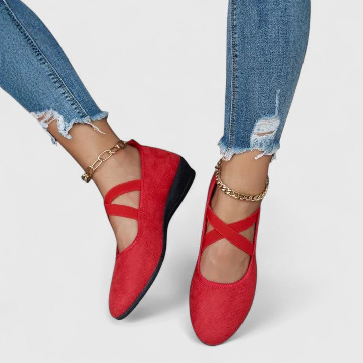 Clara red orthopedic wedge strap flats with a closed toe, worn with distressed jeans and gold anklets.