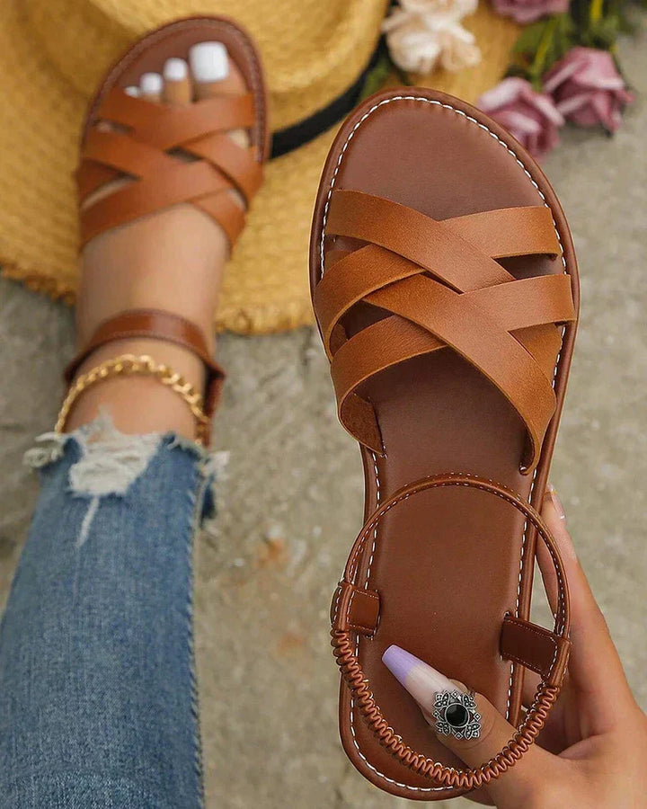 Women's Corinne flat sandals in brown with woven-look cross straps and a flexible back strap for secure, effortless style.