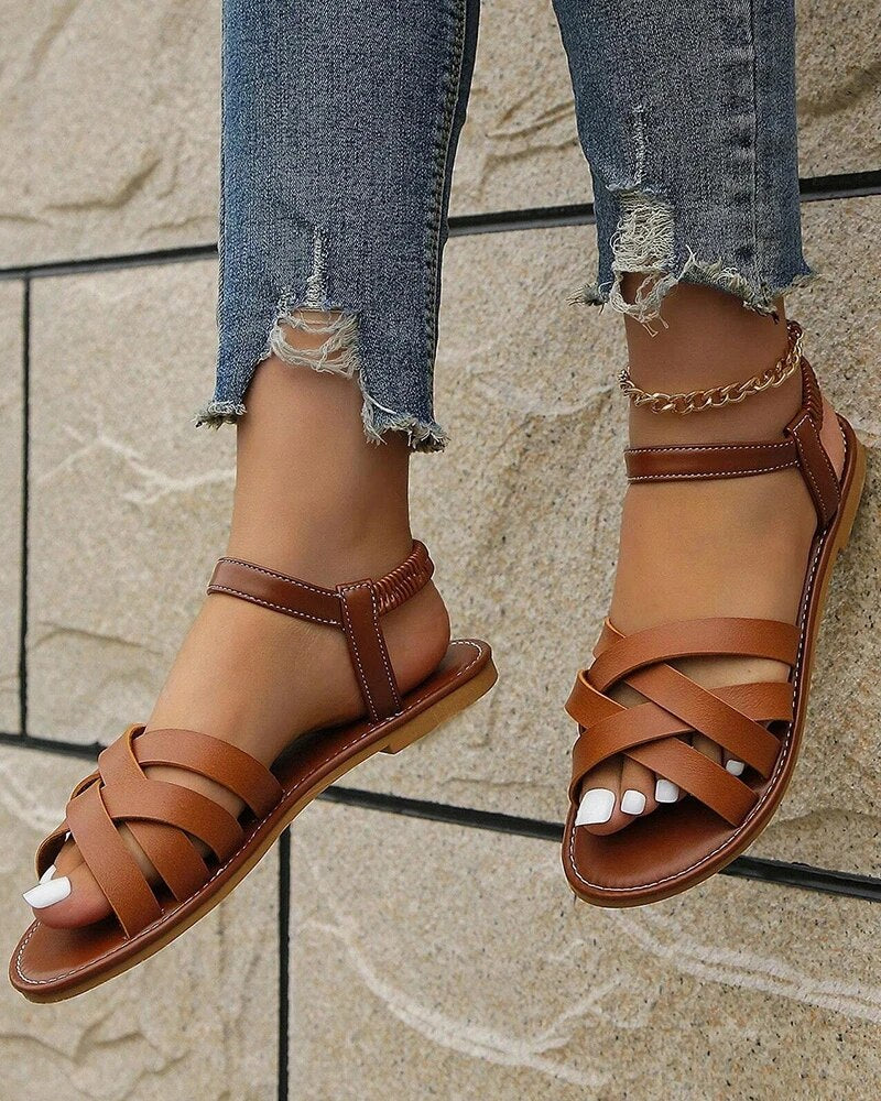 Women's Corinne brown cross strap flat sandals with a secure back strap, perfect for summer styling.