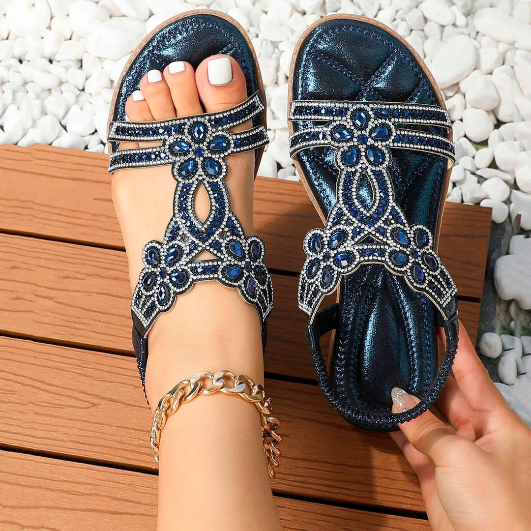 Marcella women's navy beaded T-strap sandals with sparkling blue embellishments and metallic finish.