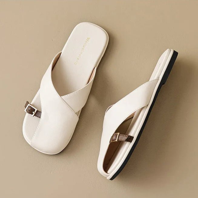 Marzella women's cream cross strap slide sandals with an open toe and slim buckle detail.