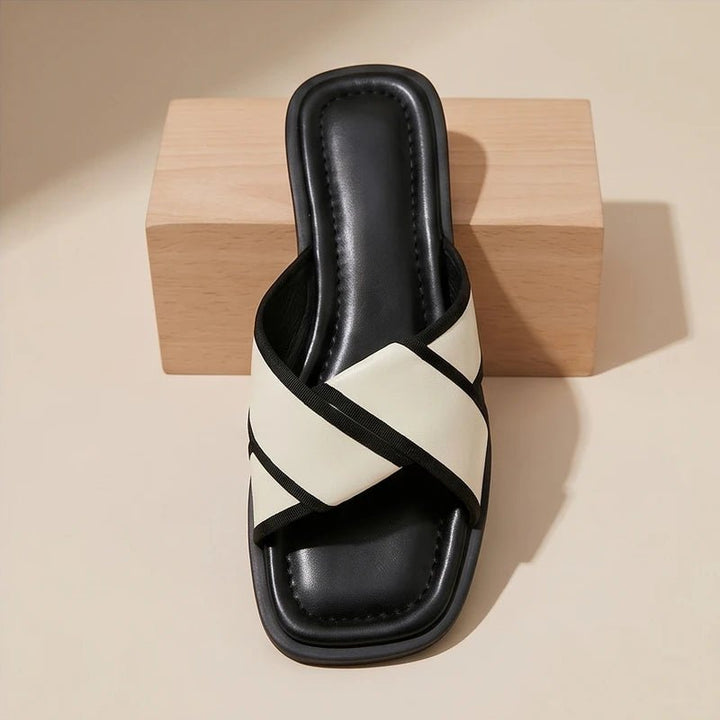 Nerissa black and white cross strap slide sandals with a square toe and contrast trim.