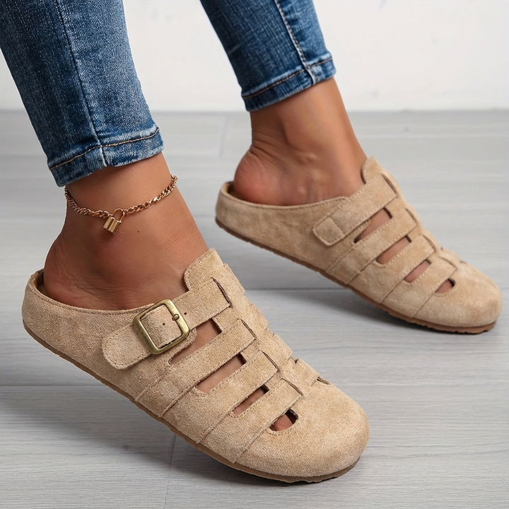Nora women's buckle strap slip-on mule sandals in a natural beige suede finish with cutout detailing.