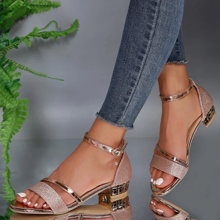 Orion women's rose gold glitter open toe ankle strap block heel sandals with metallic trim.