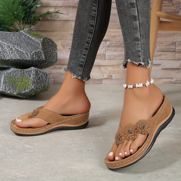 Women's Pippa floral slide sandals in tan with layered flower details, contrast stitching, and a low sole.