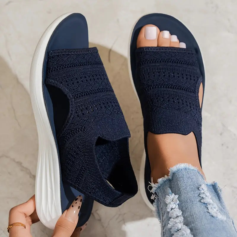 Soleil women's navy knit slip-on sandals with an open toe, side cutouts, and a cushioned white sole.