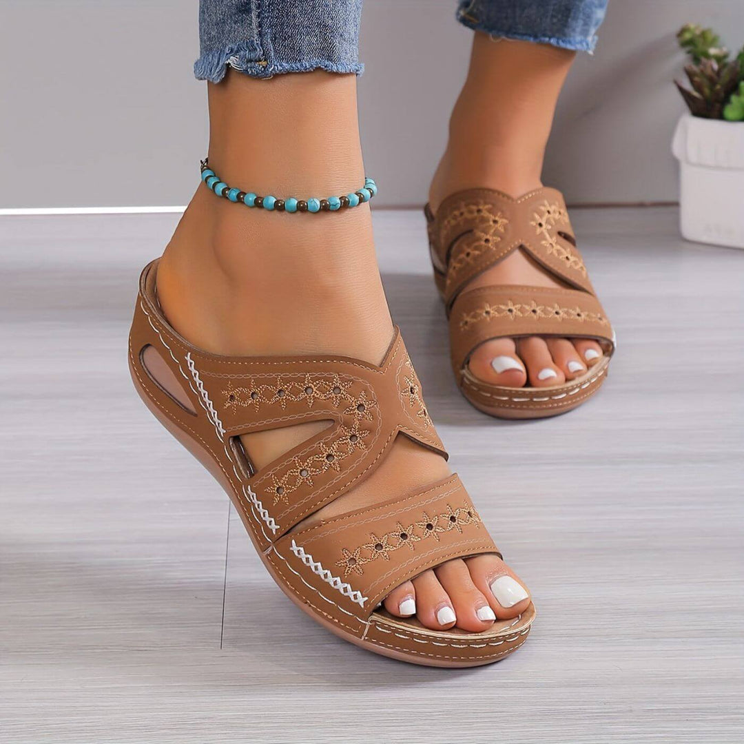 Women's Soleva brown embroidered wedge slide sandals with side cutouts and a low wedge sole.