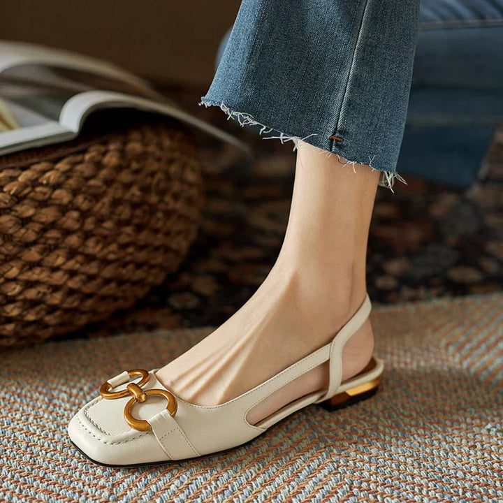 Verena women's slingback buckle flats in polished off-white with a gold-tone buckle and low flat heel.