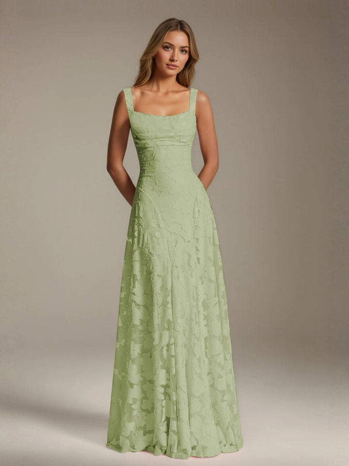 Woman in a floor-length, A-line Adrienne floral bridesmaid dress with a square neckline and delicate green lace.