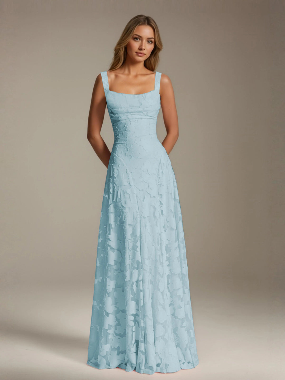 Adrienne light blue floral lace A-line bridesmaid gown with square neckline, worn by a woman.