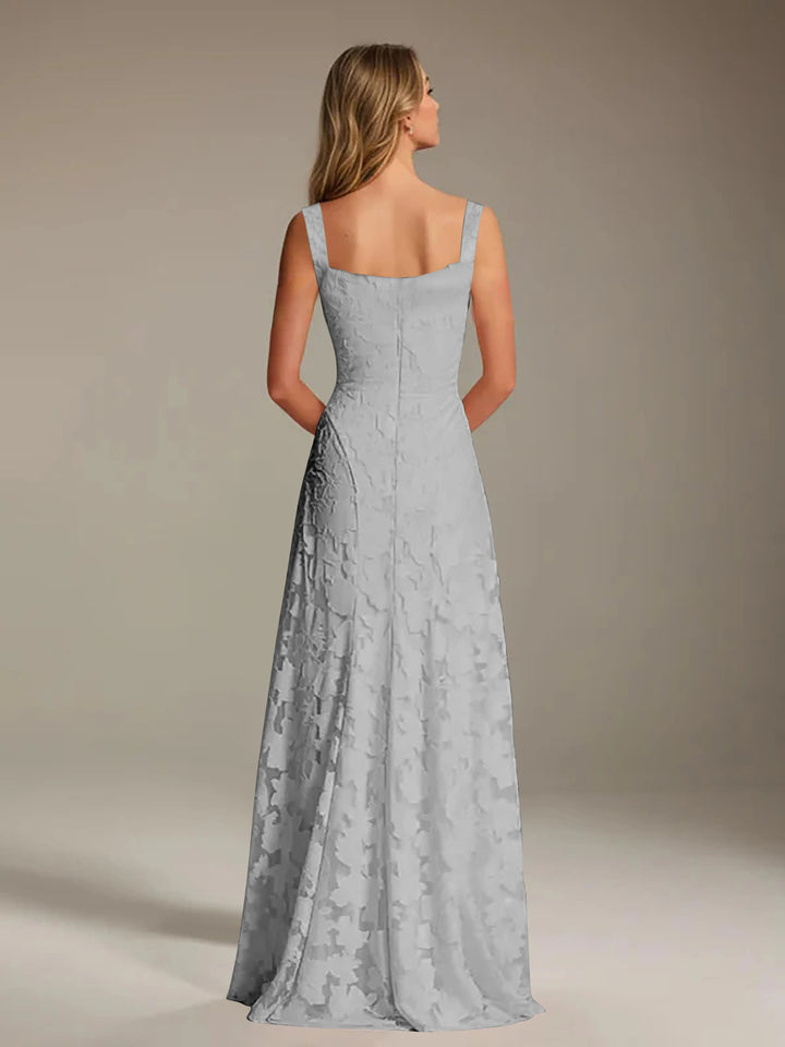 Woman in a light gray Adrienne floral lace A-line bridesmaid gown with a square neckline, viewed from the back.