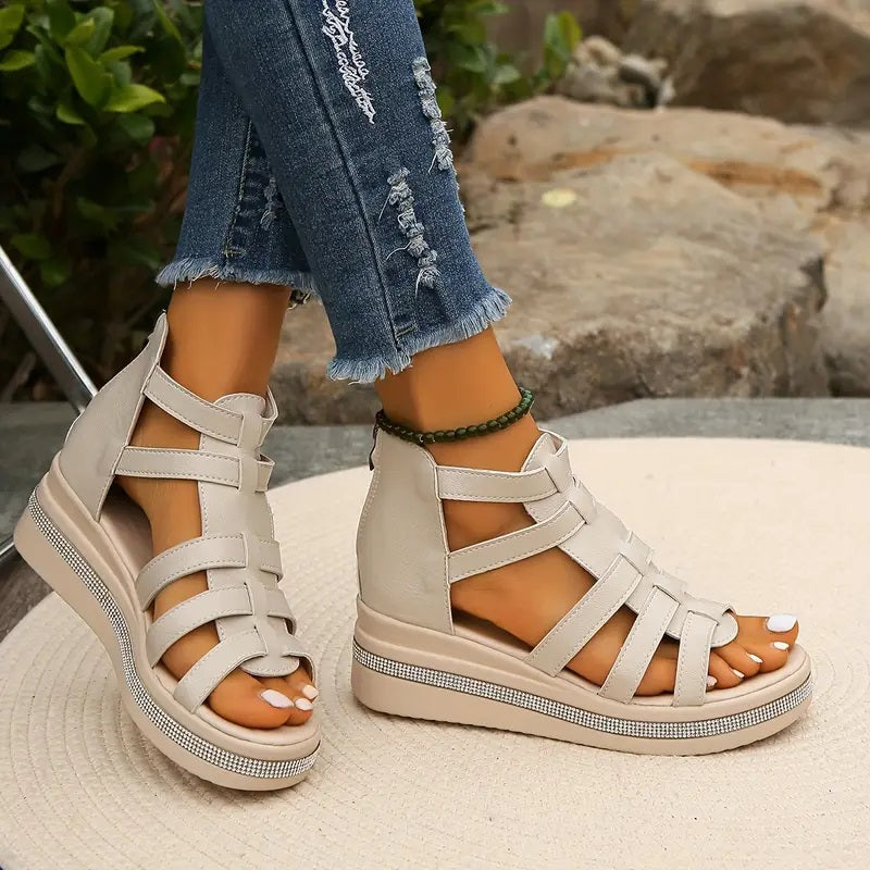 Beige platform gladiator sandals with strappy upper, open toe, and rhinestone-embellished sole.