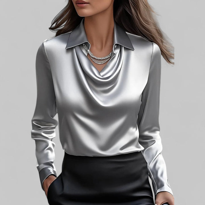Woman wearing the Aria silver satin long-sleeve blouse with a draped cowl neckline and collar.