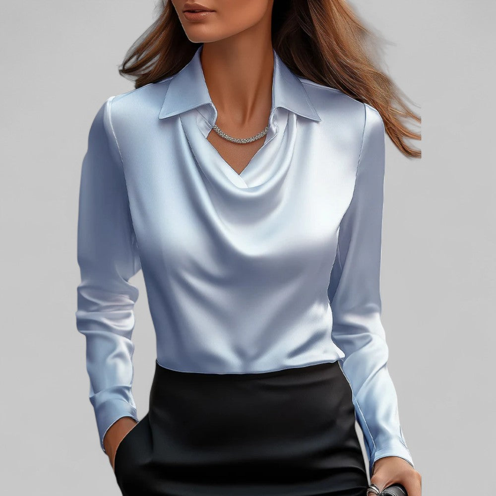 Woman wearing the light blue Aria satin blouse with a draped cowl neck and collar.
