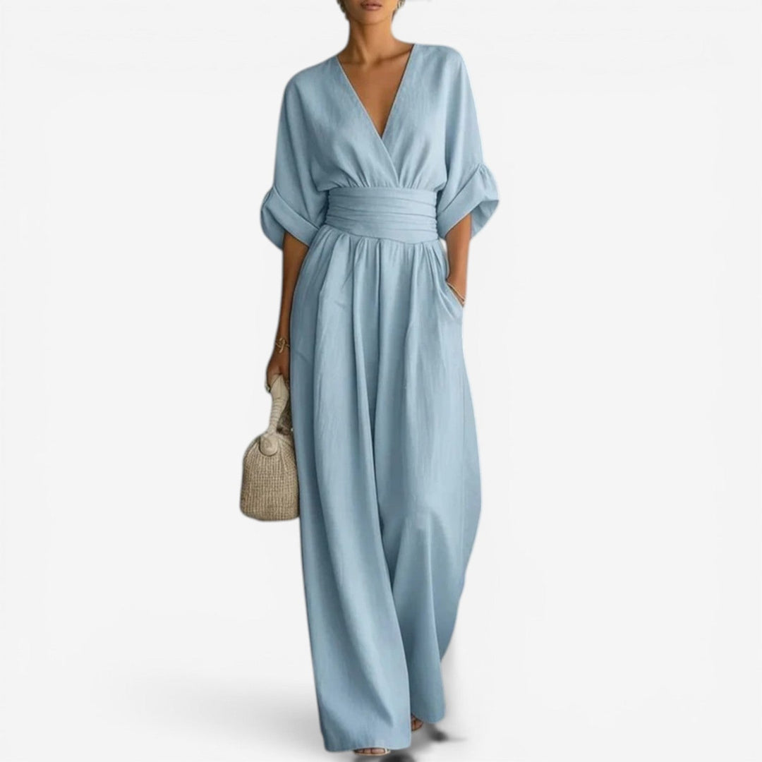 Light blue wide-leg jumpsuit with a V-neck, cinched waist, and airy wide sleeves in a soft, flowing fabric.