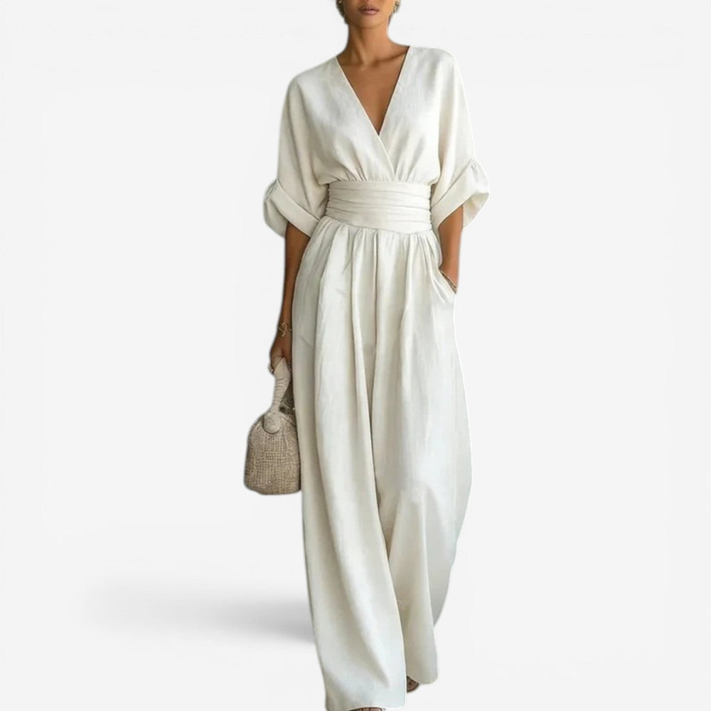 Cream-colored wide-leg jumpsuit with a V-neckline, cinched waist, and airy wide sleeves in a lightweight fabric.