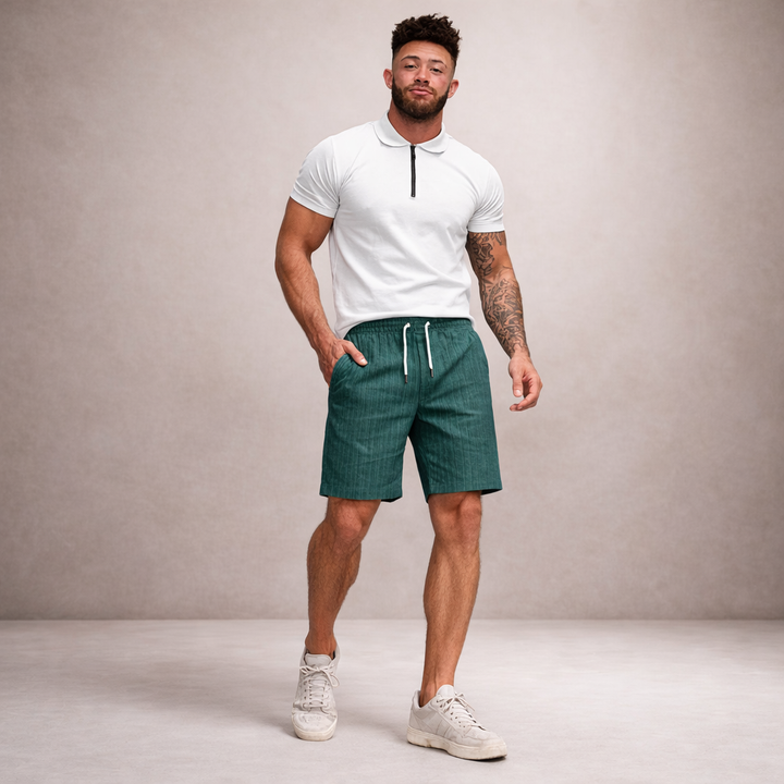 Men's Brandon drawstring linen summer shorts in teal, worn with a white polo shirt.
