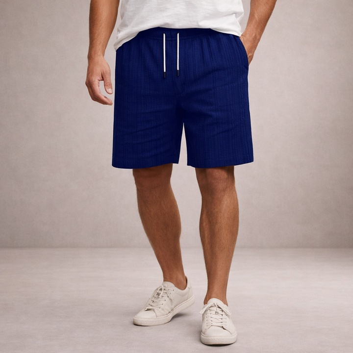 Men's navy blue linen drawstring shorts with textured fabric, above-knee length, and side pockets.