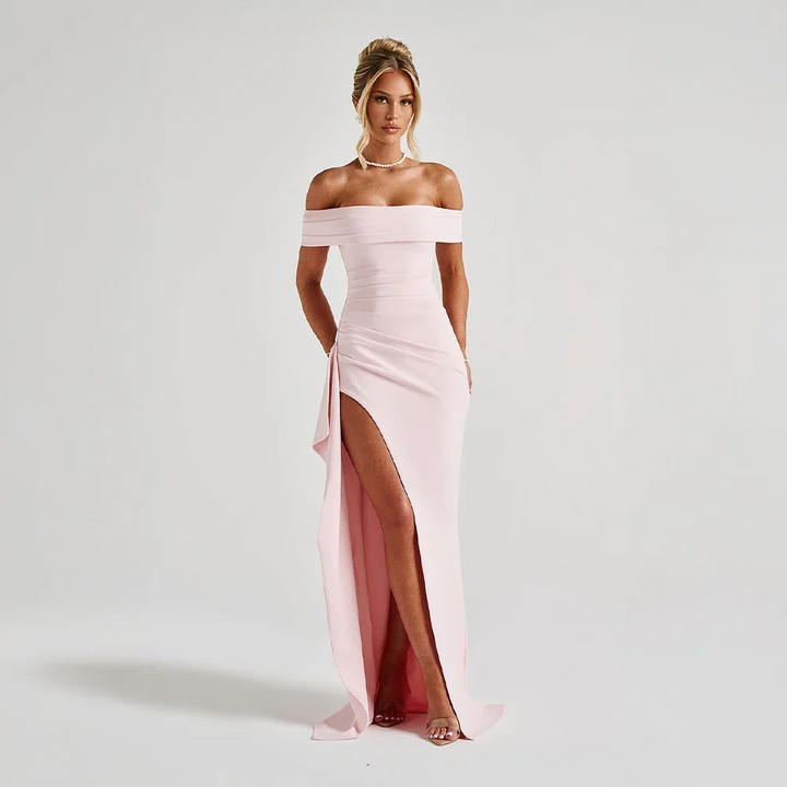 Pink off-shoulder maxi dress with a high slit, flowing fabric, and elegant design.