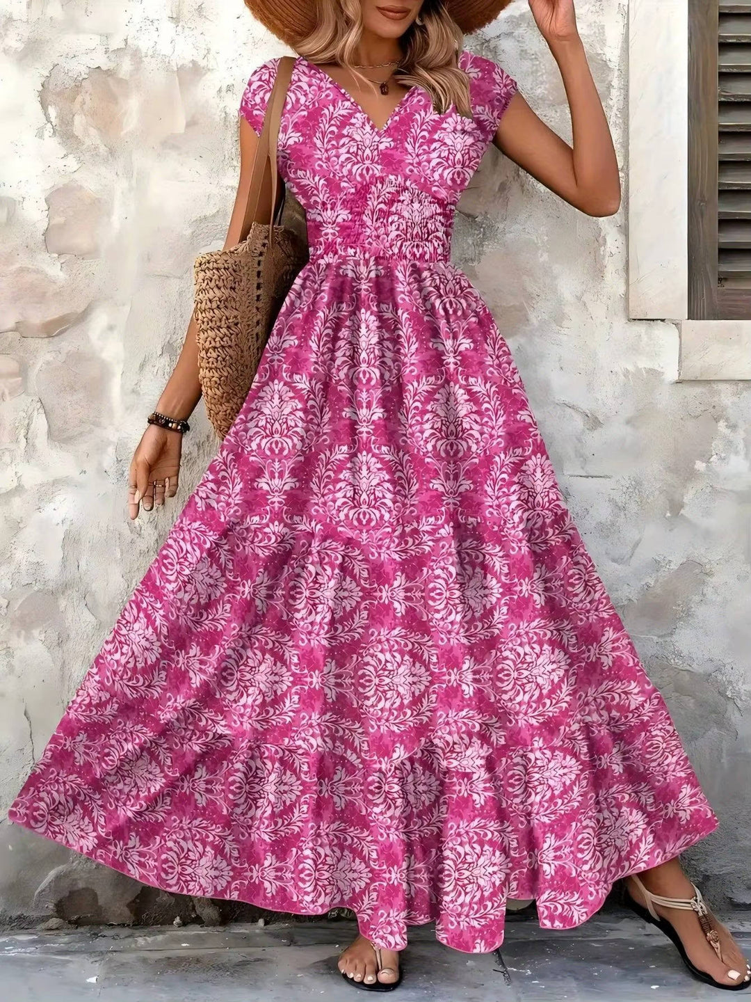 Women's pink V-neck maxi boho dress with flutter sleeves and ornate print.