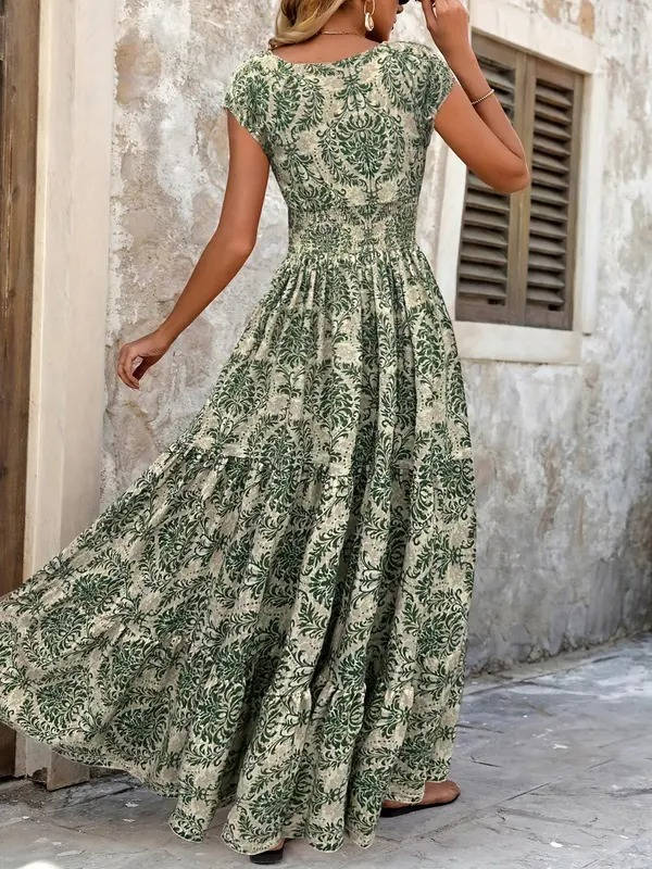 Woman in a green ornate print V-neck maxi boho dress with short flutter sleeves.