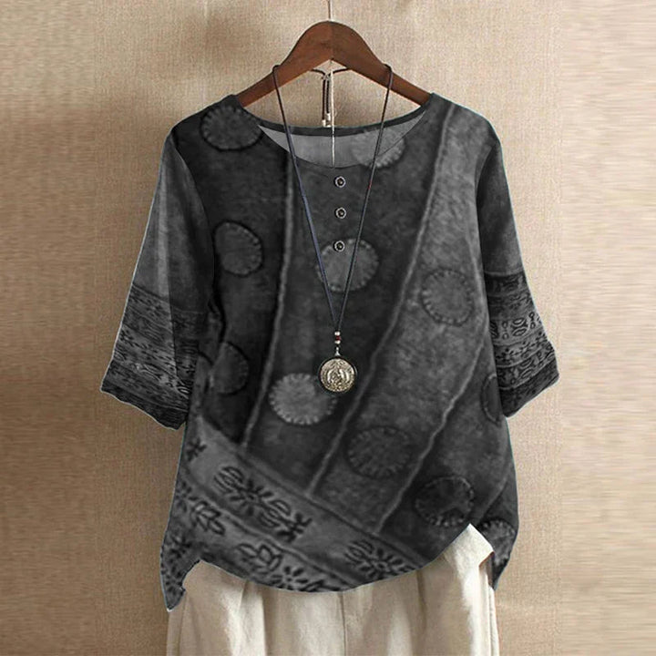 Relaxed-fit charcoal grey floral blouse with three-quarter sleeves, button-front detail, and a soft, draped silhouette.