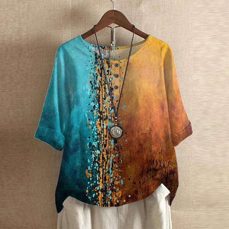 Relaxed-fit blouse featuring a teal and orange abstract floral print, half-sleeves, and a button-down neckline.