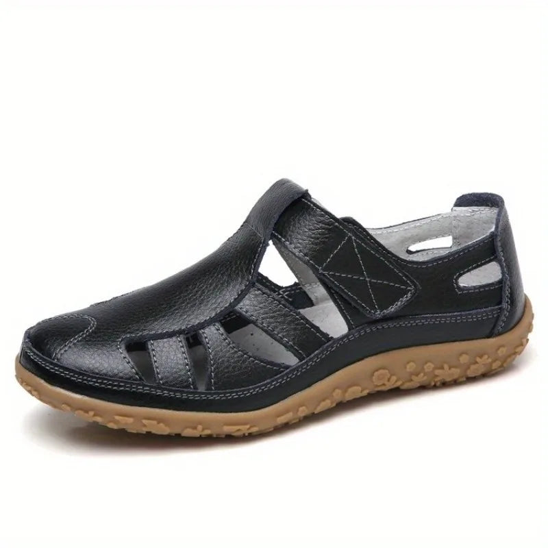 Clara black leather closed-toe fisherman sandals with a textured tan flat sole.
