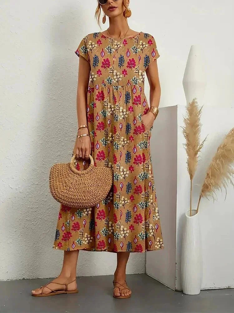 Clara women's floral cotton midi dress in a vibrant print with short sleeves and practical pockets.
