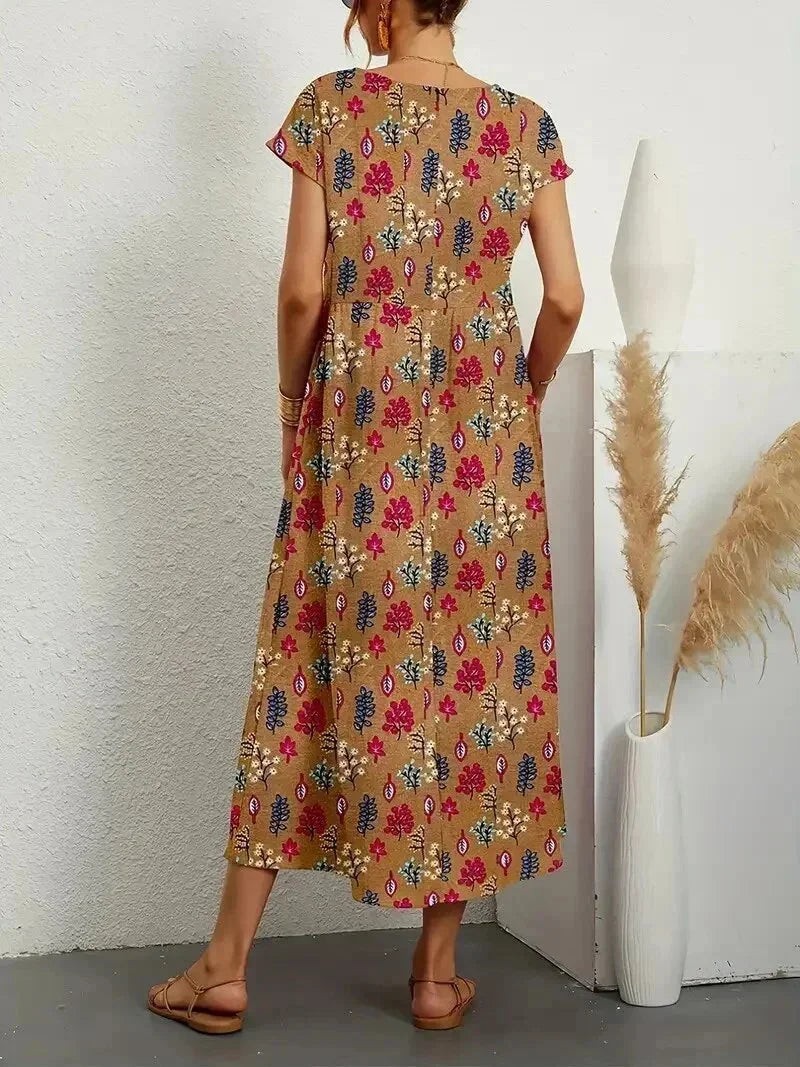 Clara floral cotton midi dress with short sleeves and pockets, perfect for warm-weather ease.