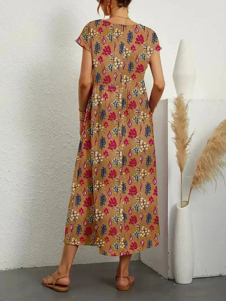 Clara floral cotton midi dress with short sleeves and pockets, perfect for warm-weather ease.