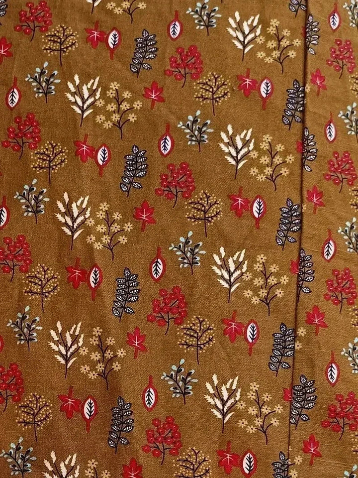 Clara women's floral cotton midi dress in a vibrant brown print with red, white, and blue leaves.