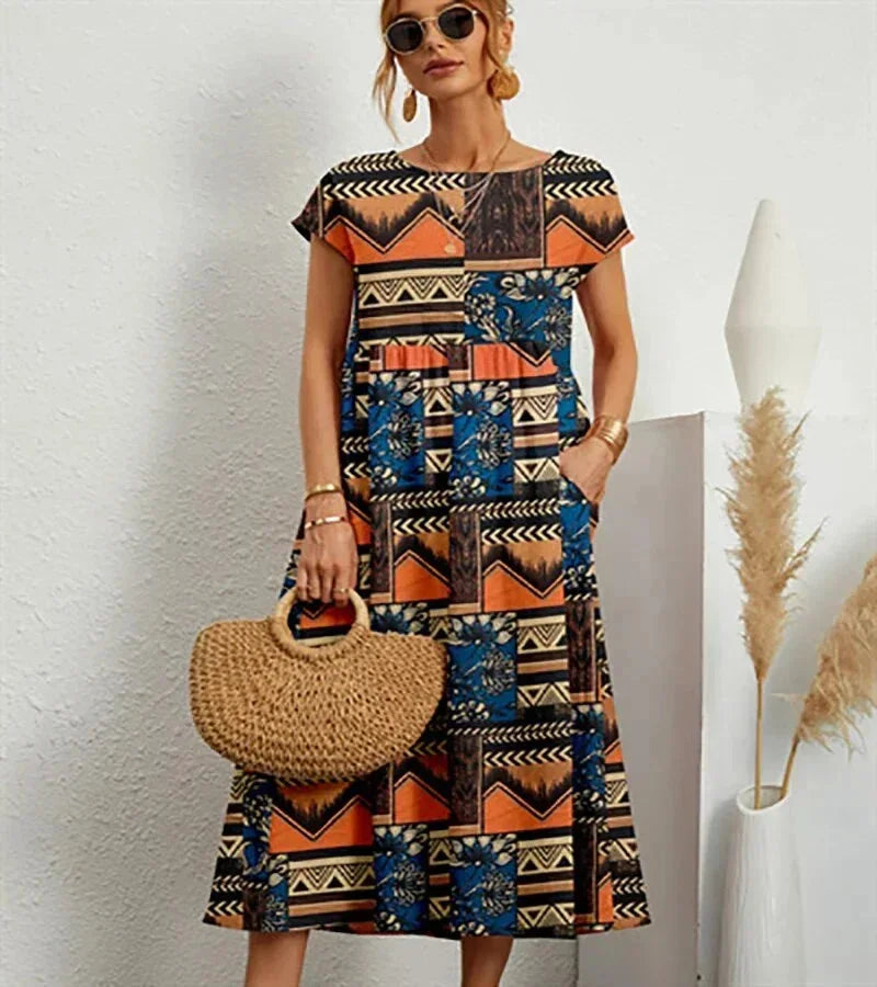 Clara women's floral cotton midi dress with short sleeves, practical pockets, and a vibrant print.