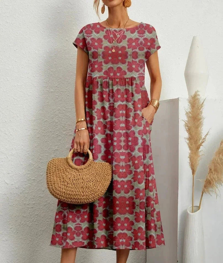 Clara floral cotton midi dress with short sleeves and pockets, perfect for warm-weather ease.