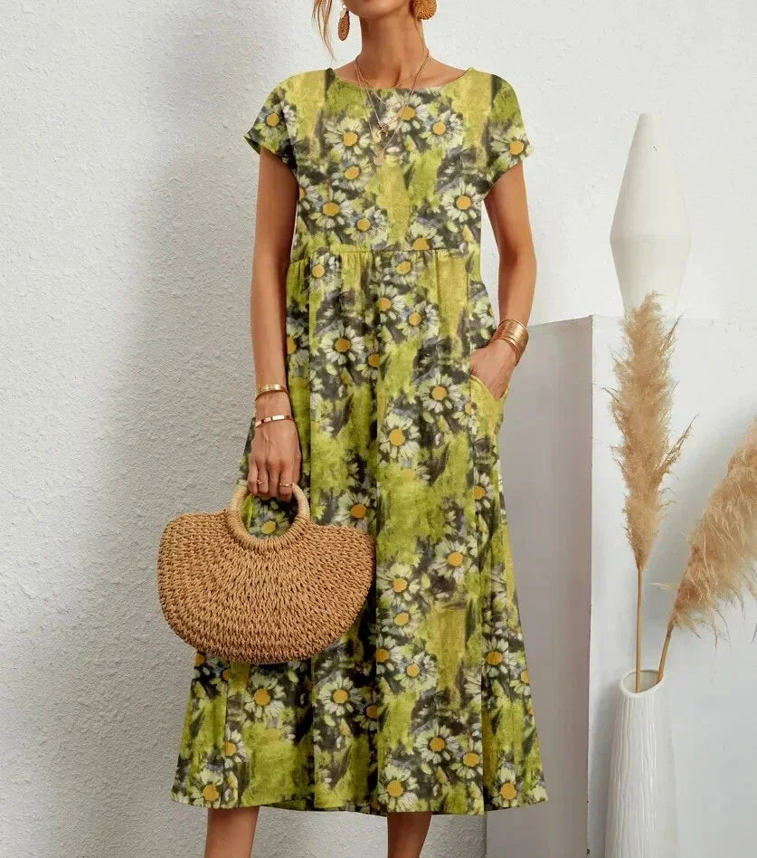 Clara floral cotton midi dress with short sleeves and pockets, perfect for warm-weather ease.