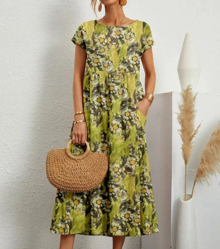 Clara floral cotton midi dress with short sleeves and pockets, perfect for warm-weather ease.