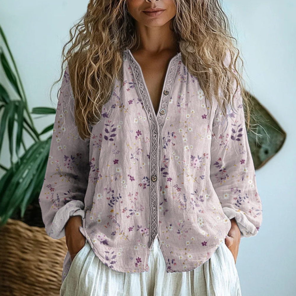 Light pink linen button-down blouse featuring a delicate floral print and decorative contrast trim along the placket.