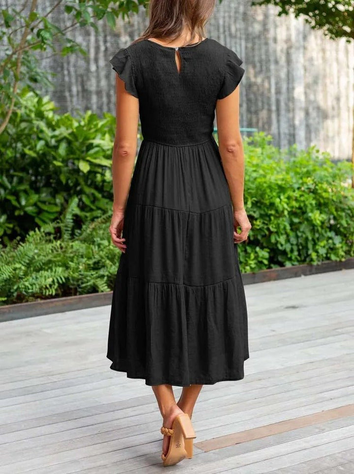 Clara women's black tiered cap sleeve midi dress, featuring a fitted bodice and flowing A-line skirt.