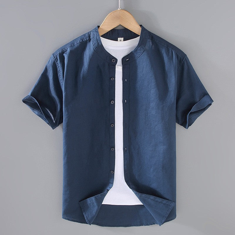 Men's Cole navy short sleeve linen shirt with a stand collar, open over a white tee.