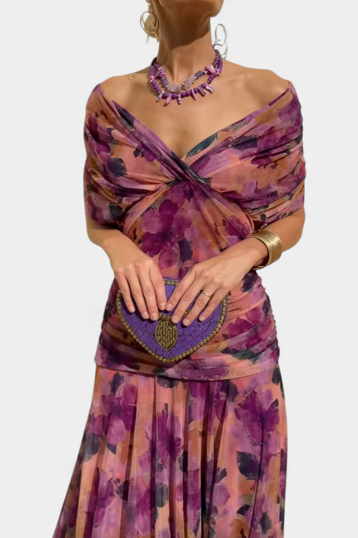 Purple floral off-shoulder maxi dress with a ruched waist, flowing skirt, and short sleeves.