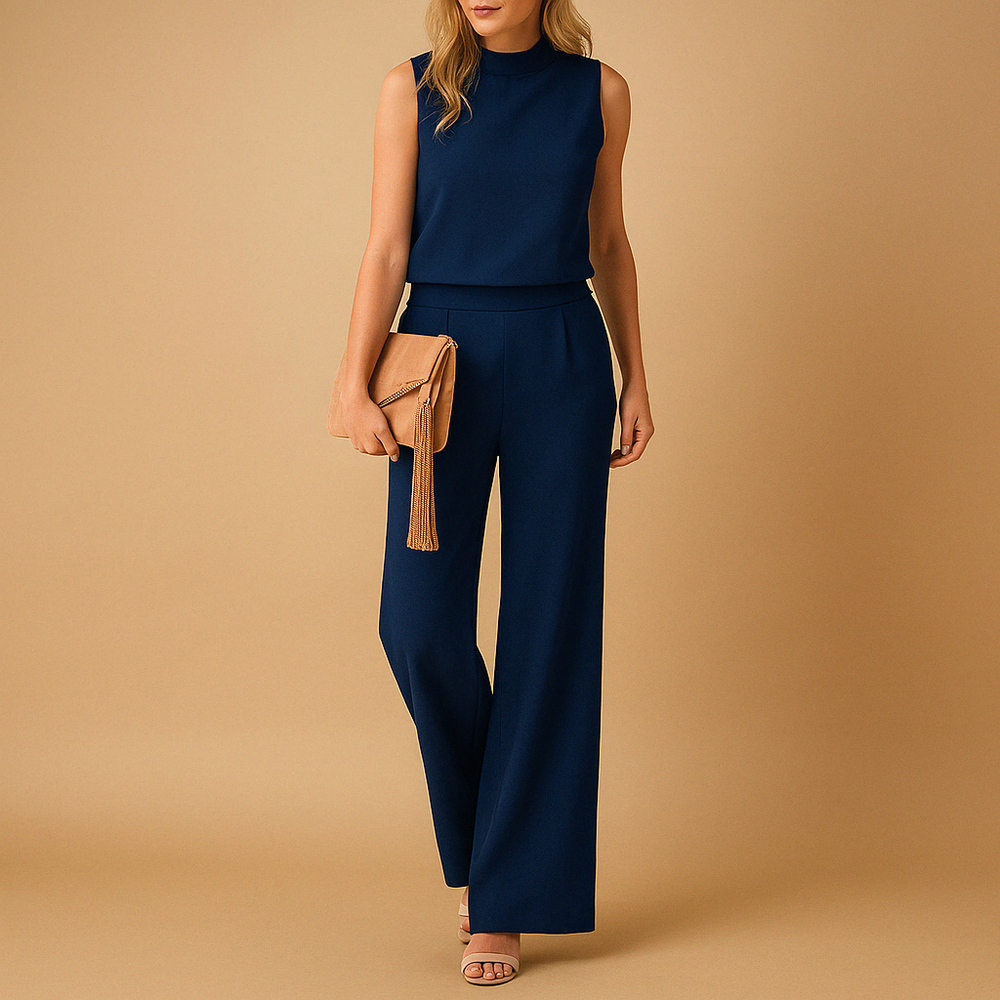 Woman in a navy sleeveless top and wide-leg pants set, holding a tan clutch with a tassel.