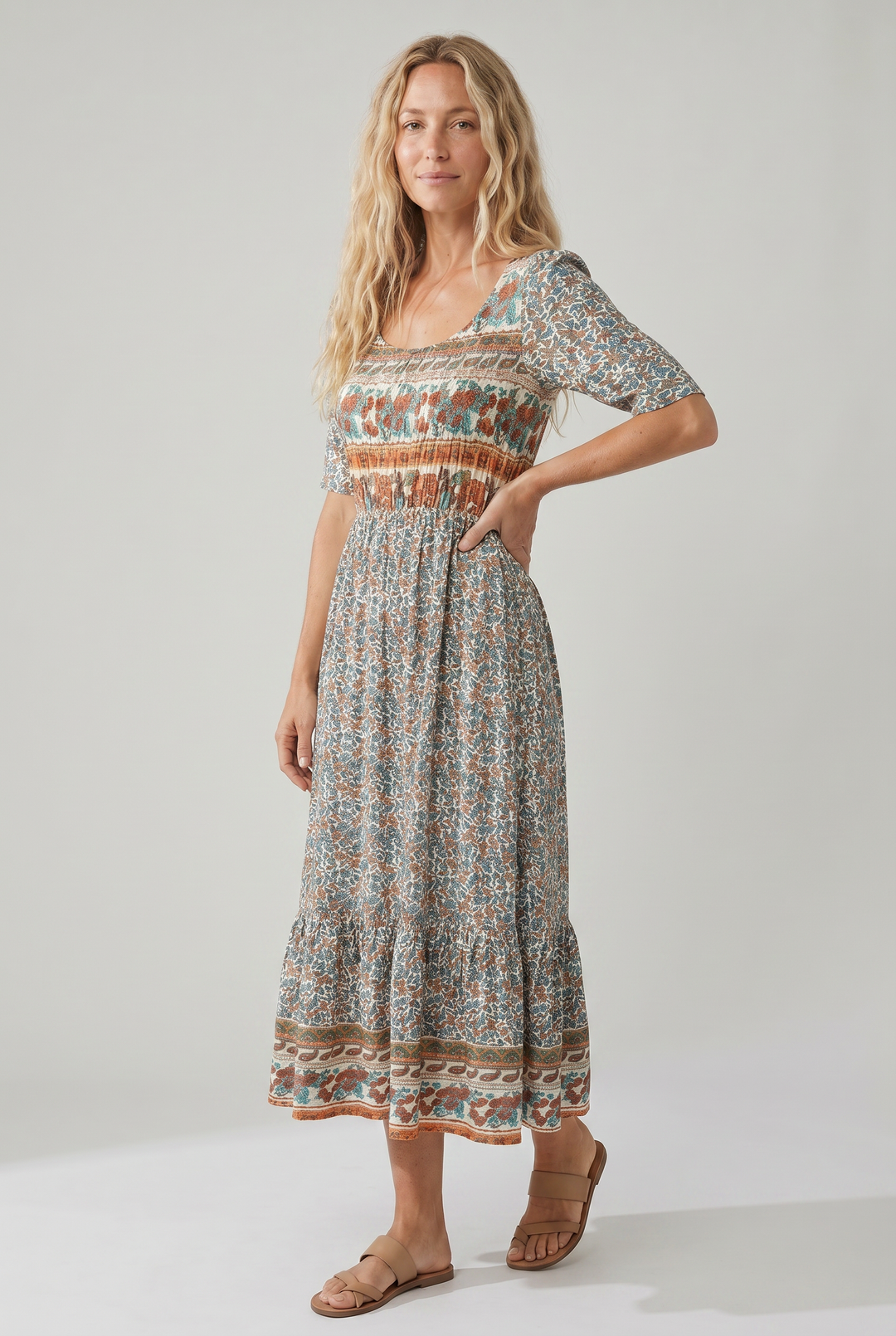 Woman in a square neck boho printed midi dress with shirred bodice and tiered skirt.