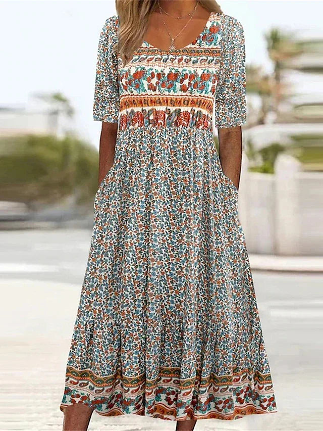 Women's Dahlia square neck boho printed midi dress with shirred bodice, tiered skirt, and pockets.