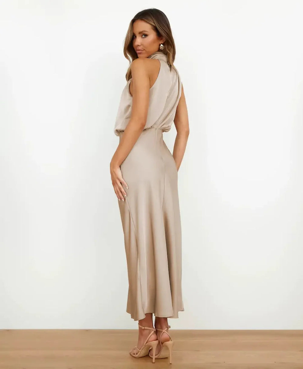 Champagne satin halter midi dress with a draped back, worn by a model.