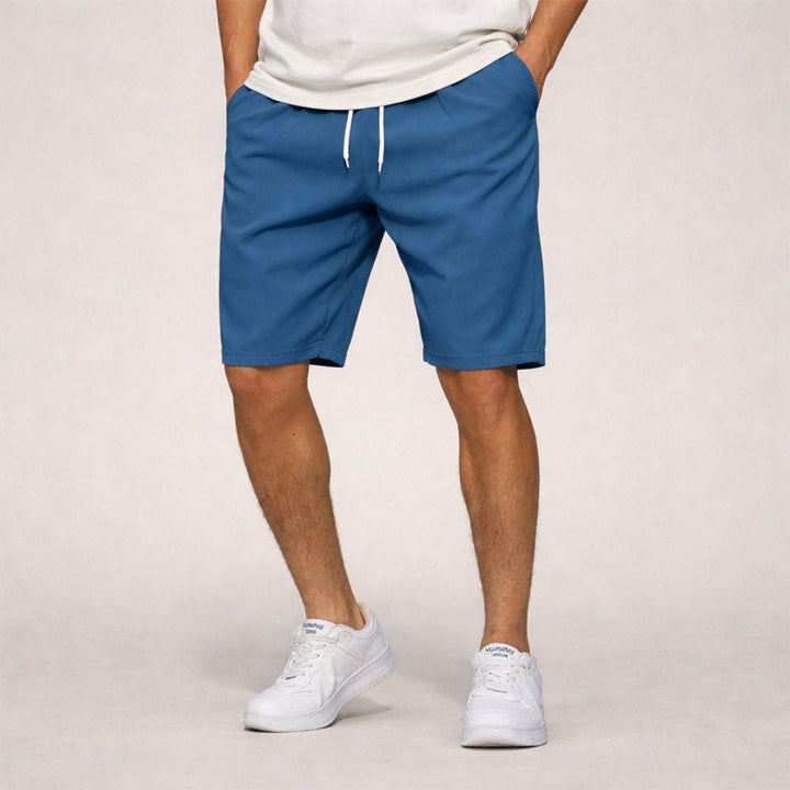 Men's Dominic drawstring knee-length shorts in blue with white drawstring and side pockets.