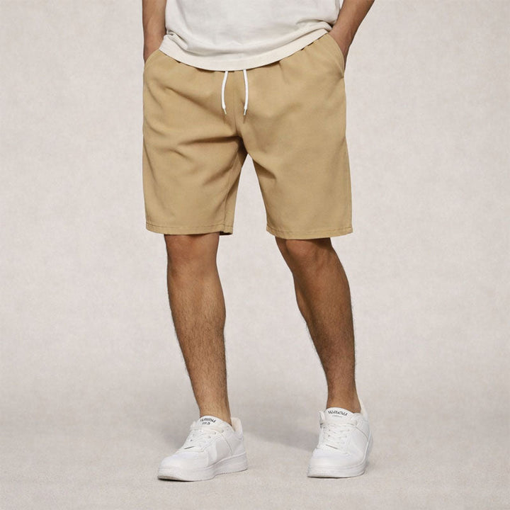 Men's Dominic knee-length drawstring shorts in tan, featuring side pockets and a relaxed fit.