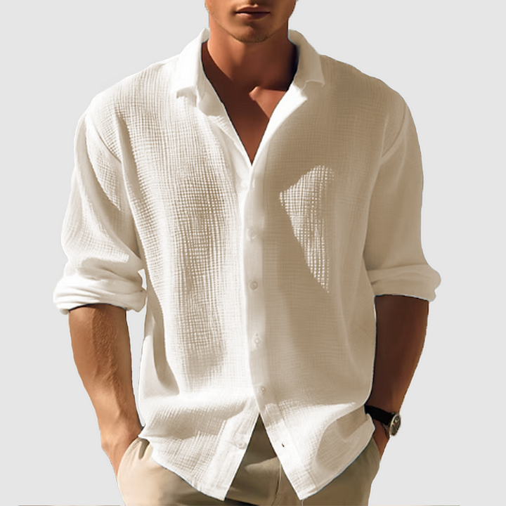 Men's white linen button-up shirt with rolled sleeves, open collar, and textured fabric.