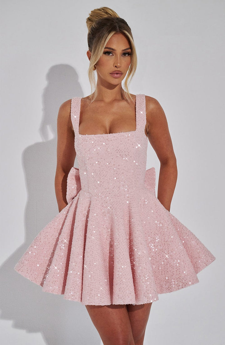 Pink sequin mini dress with a square neckline, flared skirt, and bow detail.