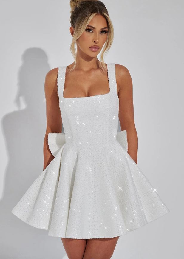 White sequin Giselle mini dress with a square neckline, flared skirt, and back bow detail.